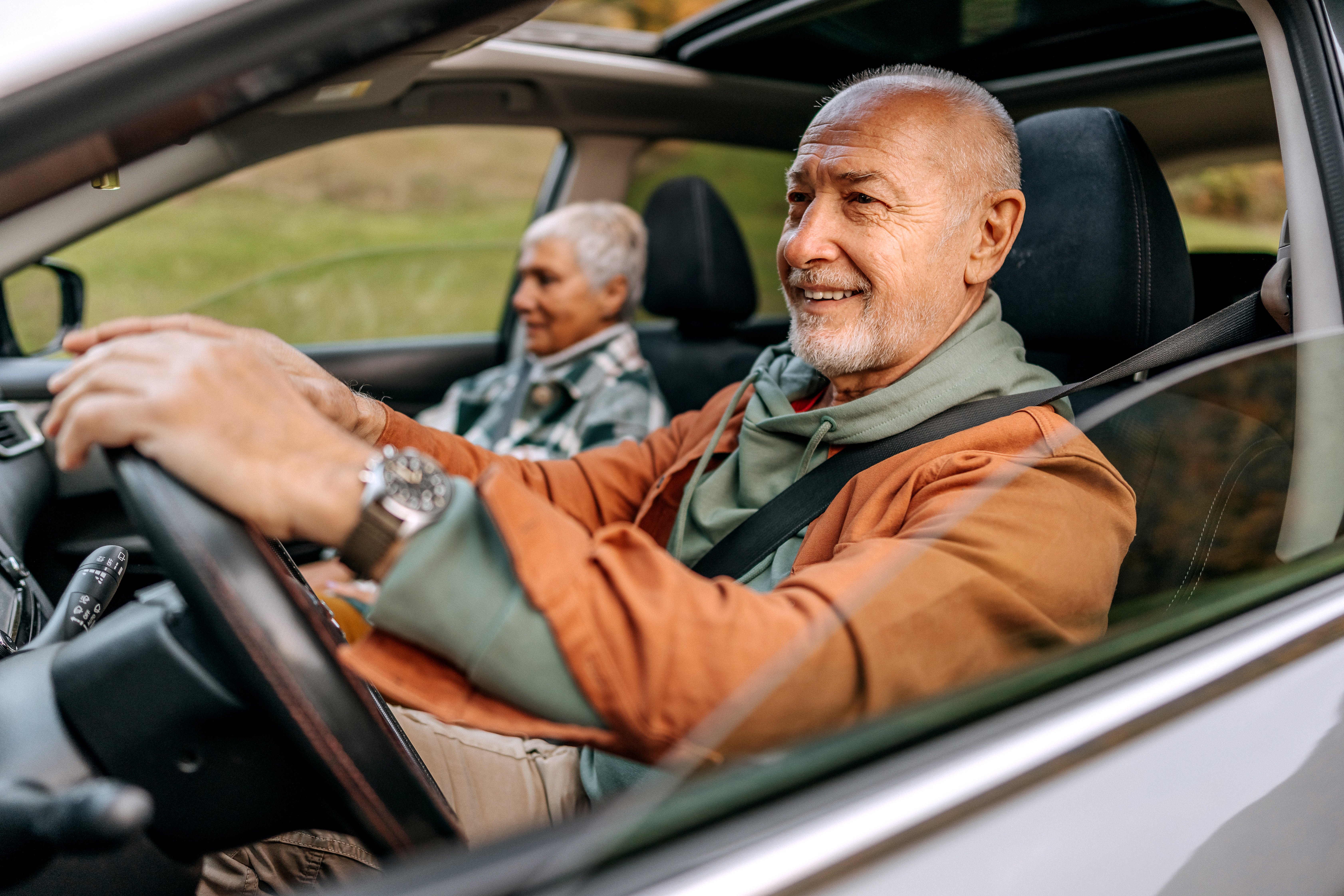 Älteres Ehepaar sitzt entspannt im Auto während eines Roadtrips